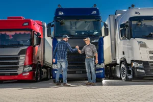 Truck operators discussing commercial fleet vehicles for pickup and registration services